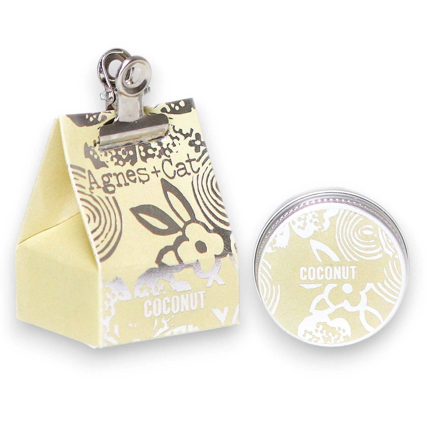 A 20g round tin of coconut-scented lip balm shown with its clean, white tropical-themed gift packaging.