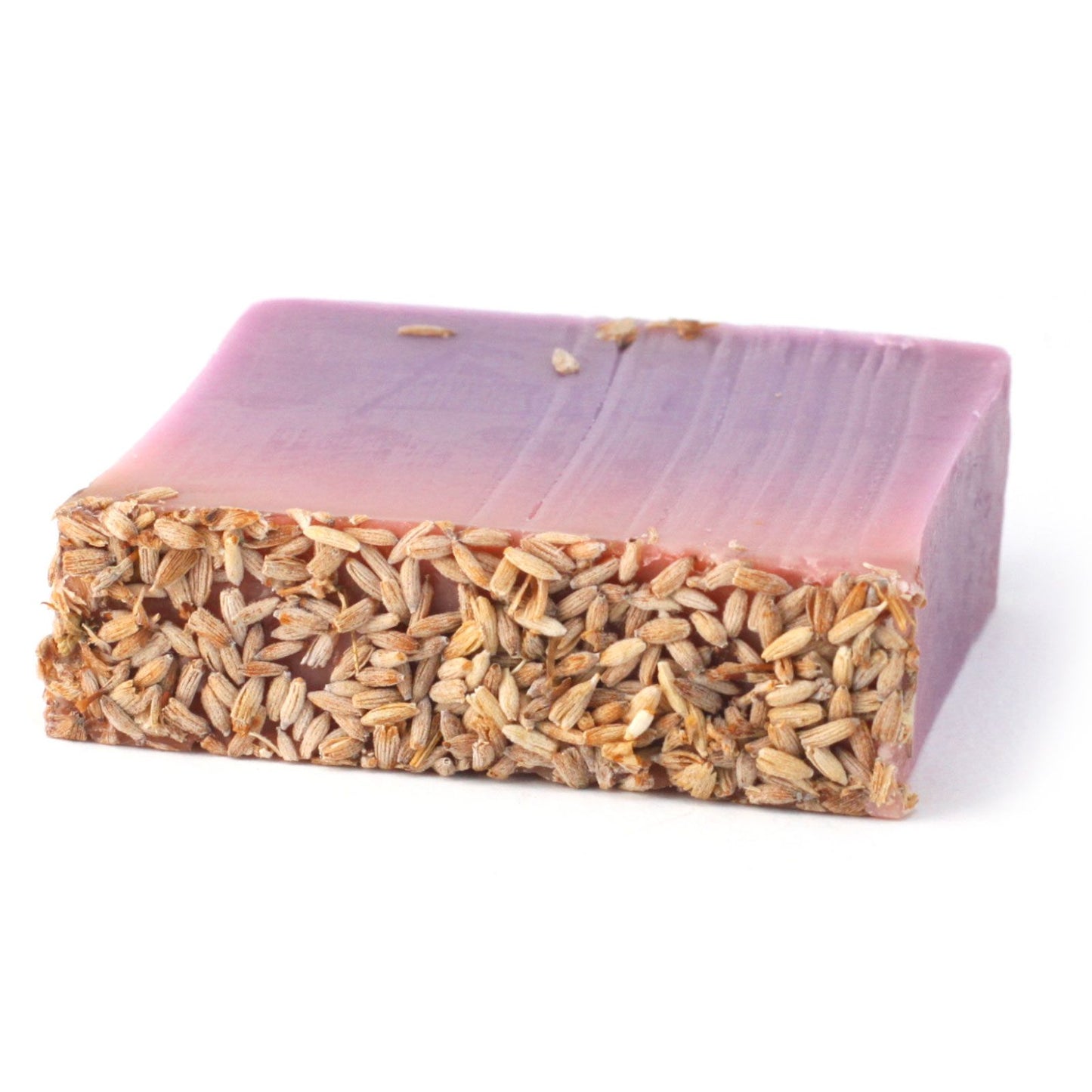 A handcrafted soap slice featuring a golden-honey textured top and creamy, botanical-filled layers.