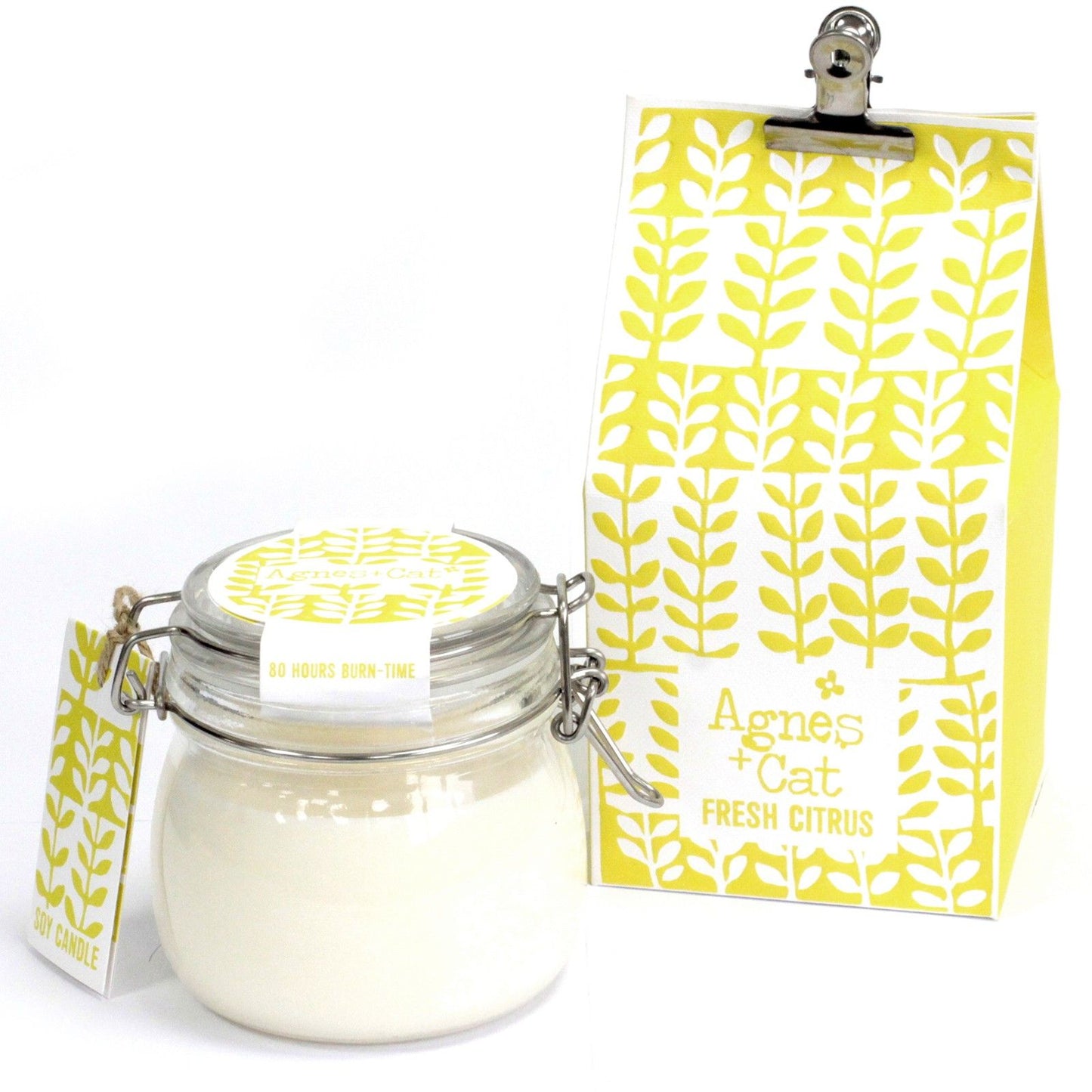 A traditional clear glass Kilner jar filled with a white scented candle and adorned with a yellow patterned decorative tag.