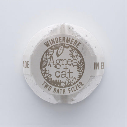 A large, elegant white bath fizzer wrapped in clear protective film with a classic blue and white label.