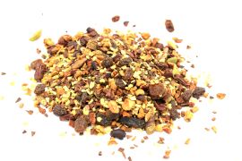 A high-volume pile of organic chai tea blend featuring whole spices and cocoa nibs for a rich chocolate infusion.