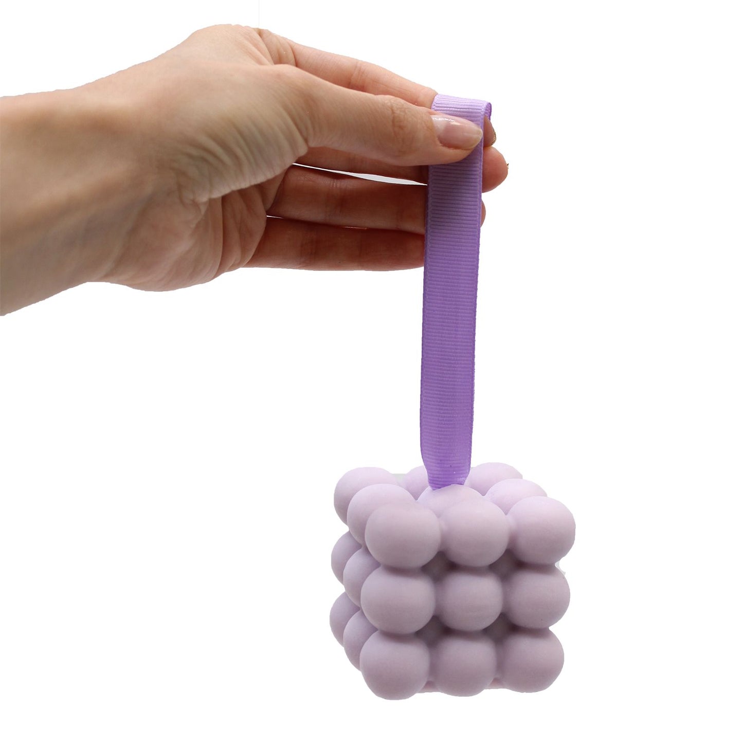 A purple massage soap bar with raised nubs for skin stimulation, scented with Lavender and Lilac, inside its individual box.