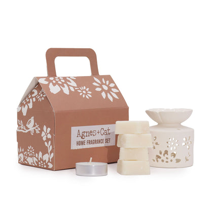 A stylish house-shaped gift box in earthy tones containing a selection of Moroccan-themed bath and fragrance products.