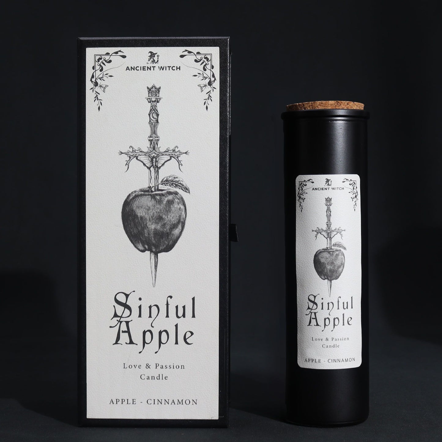 A tall black ritual candle in a premium black box with mystical apple and snake illustrations in silver.