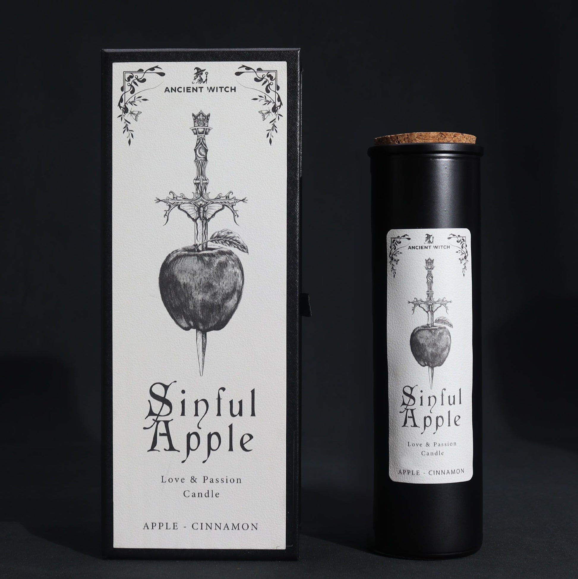 A tall black ritual candle in a premium black box with mystical apple and snake illustrations in silver.