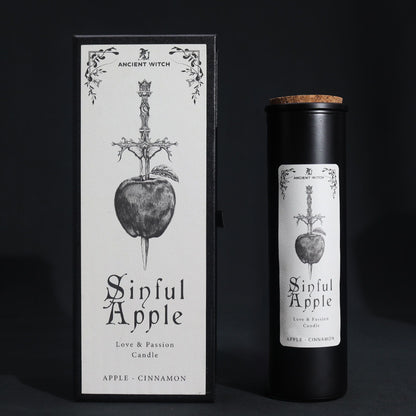 A tall black ritual candle in a premium black box with mystical apple and snake illustrations in silver.