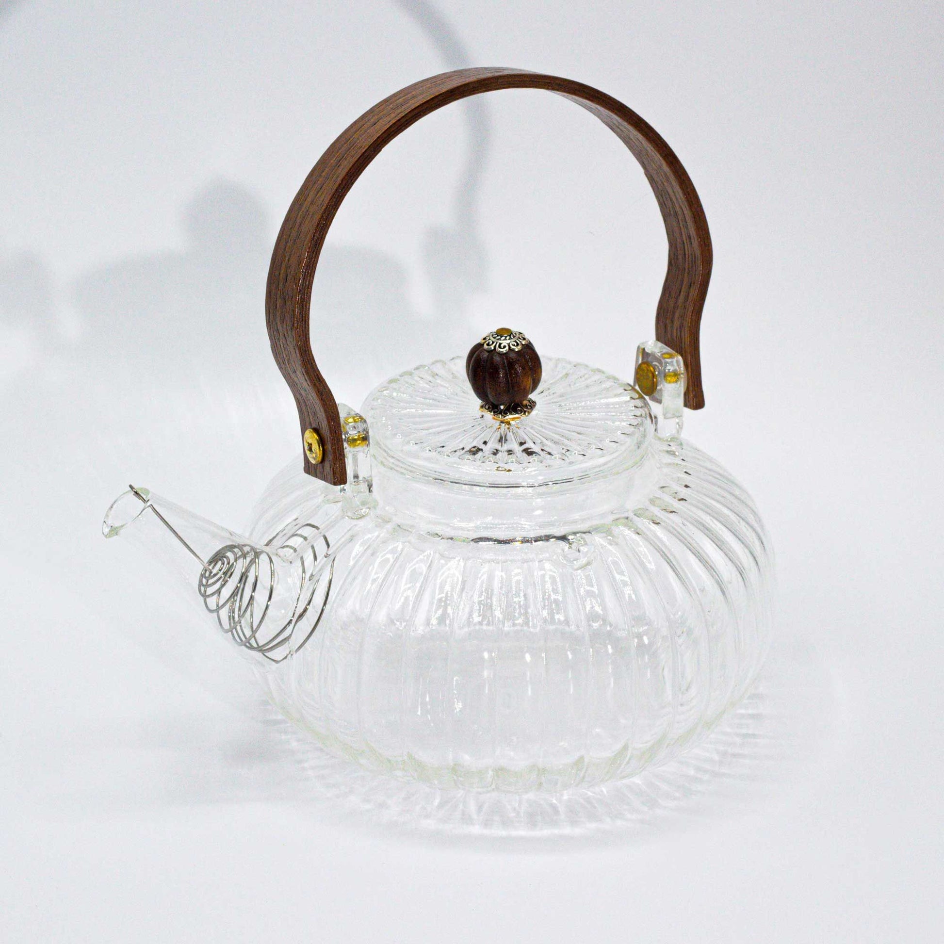 A medium-sized round glass teapot with vertical ribbed texture and a traditional curved glass handle.