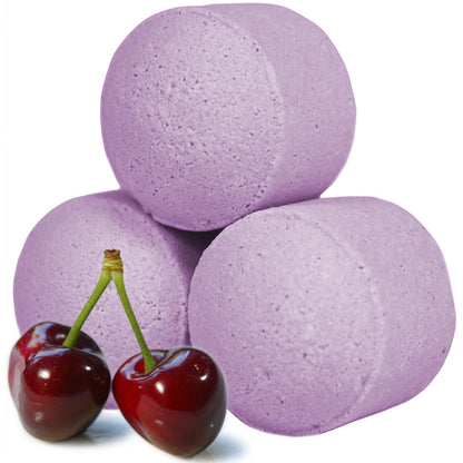 A bulk quantity of deep purple mini bath bombs shown with ripe black cherries for a decadent visual appeal.