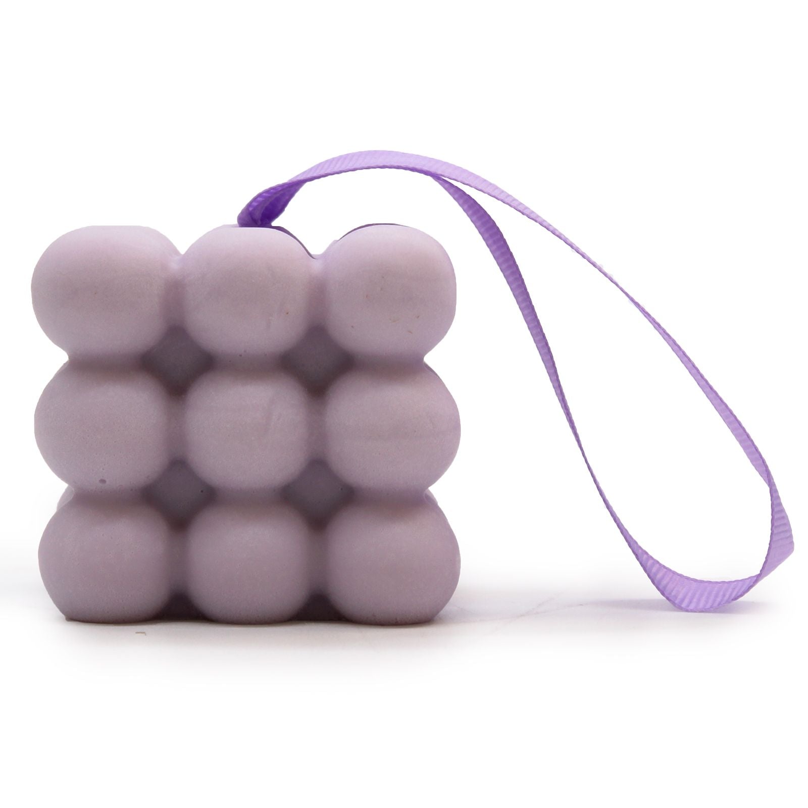 A purple massage soap bar with raised nubs for skin stimulation, scented with Lavender and Lilac, inside its individual box.