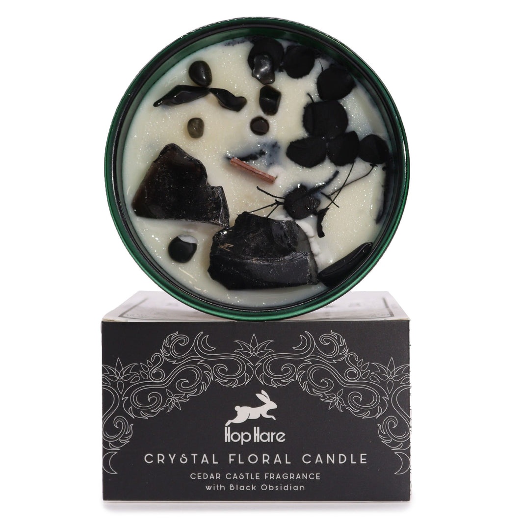 The King of Swords Tarot candle featuring a raw crystal point and floral elements in a dark glass jar for mental focus.