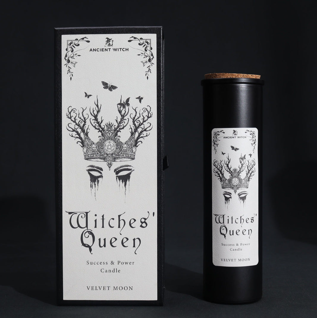 A tall, slim black pillar candle elegantly boxed in a dark, occult-inspired cardboard sleeve with silver foil details.