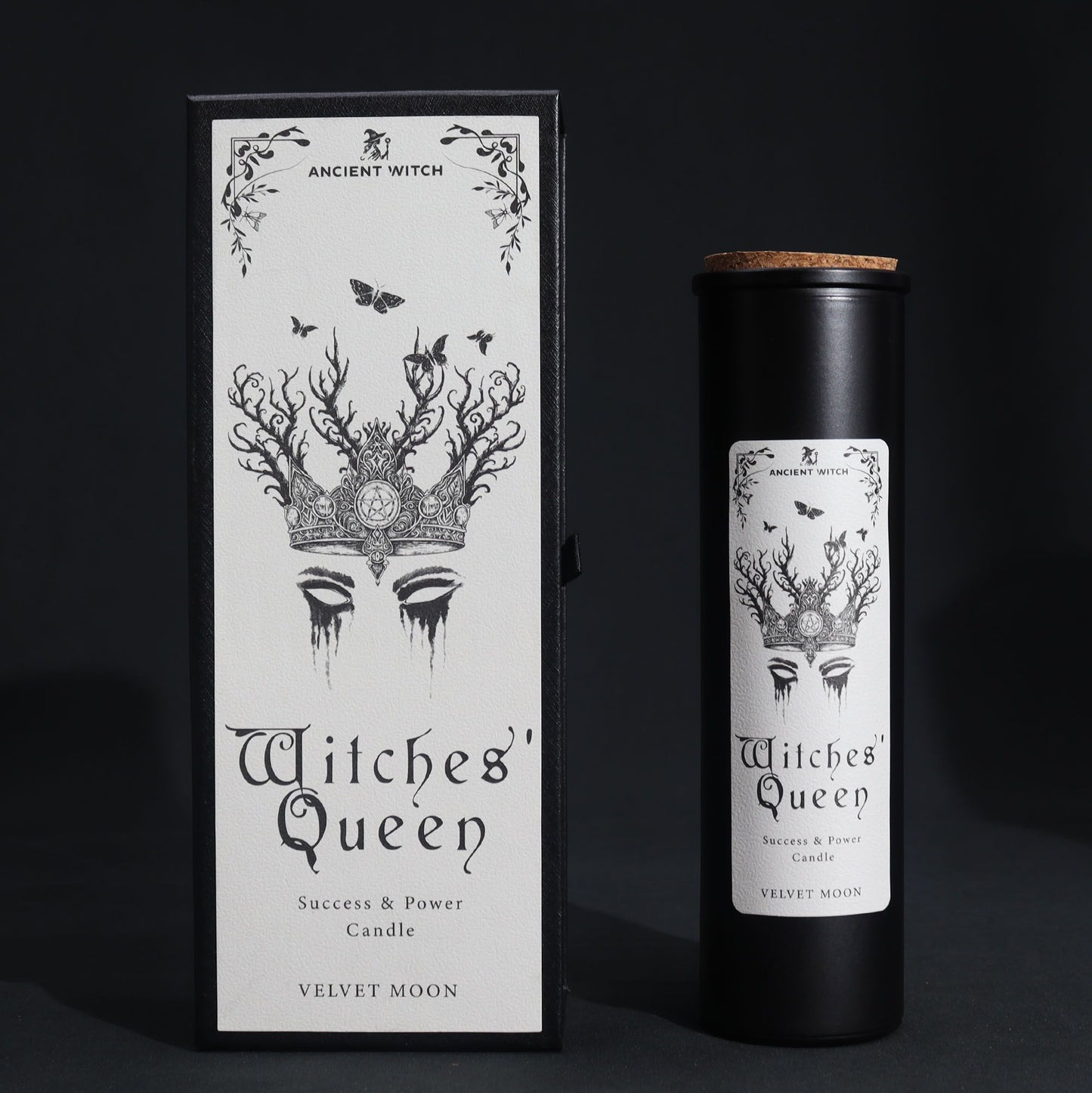 A tall, slim black pillar candle elegantly boxed in a dark, occult-inspired cardboard sleeve with silver foil details.