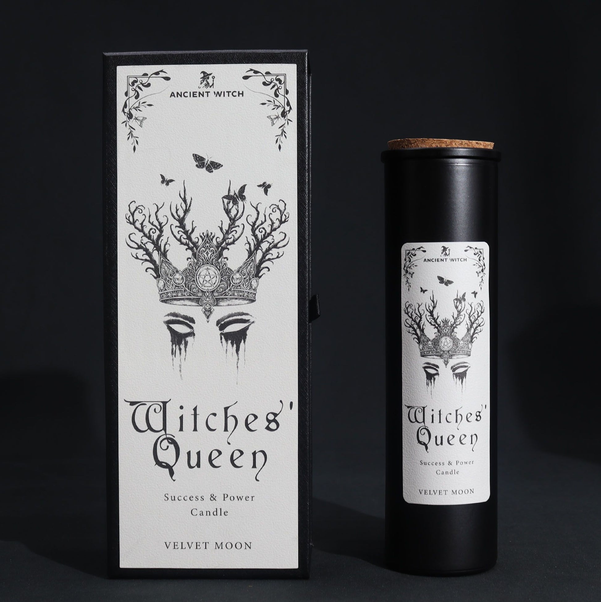 A tall, slim black pillar candle elegantly boxed in a dark, occult-inspired cardboard sleeve with silver foil details.