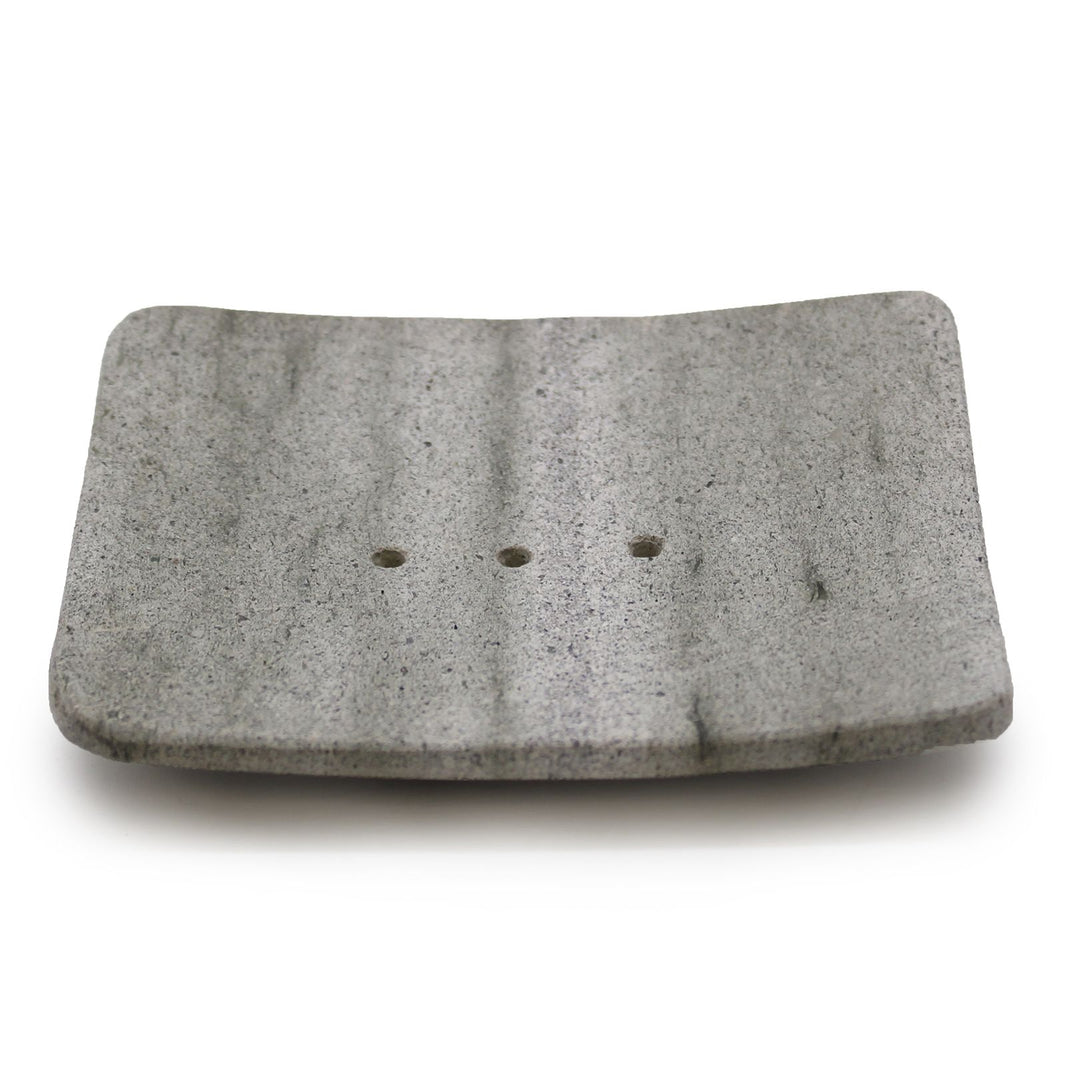 A square-shaped natural grey stone soap dish made from porous Zeolite (Ziolit) stone for quick-drying soap storage.