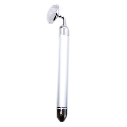 A polished clear rock quartz gemstone vibration pad designed for stimulating facial rituals and skincare absorption.