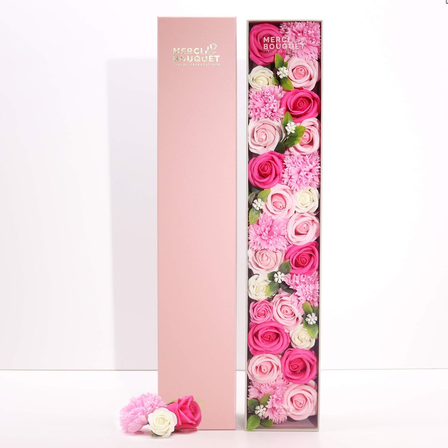 A tall, slender gift box featuring pink floral designs and delicate baby motifs, housing a selection of premium bath treats.