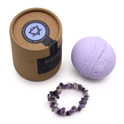 A purple bath bomb shown alongside an elasticated bracelet made of polished purple amethyst gemstone beads.