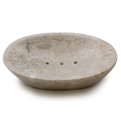 A wide, shallow oval soap dish made from polished cream-colored marble featuring natural dark grey speckles.