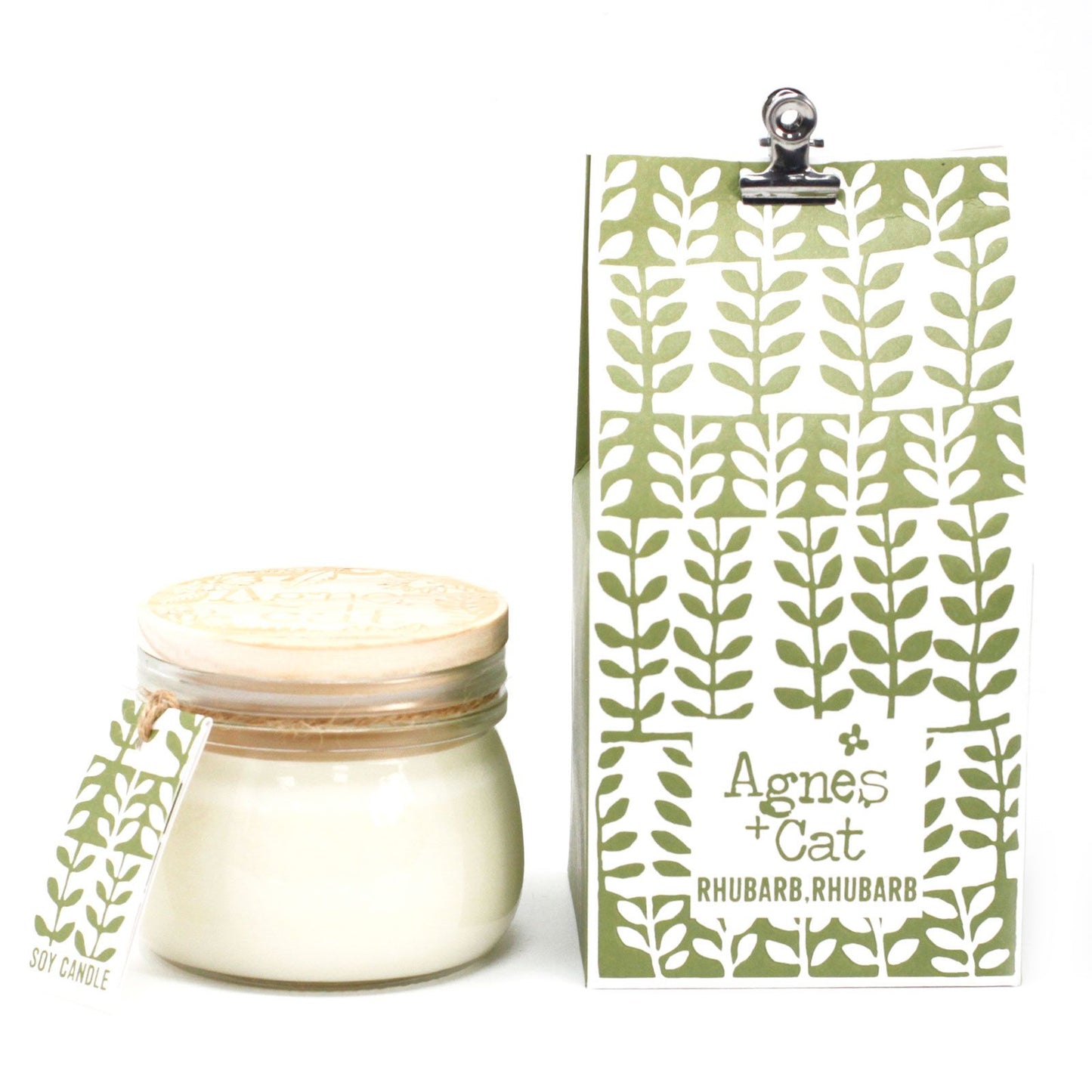 A small glass jar candle featuring a green and white botanical rhubarb label and a classic silver airtight seal.