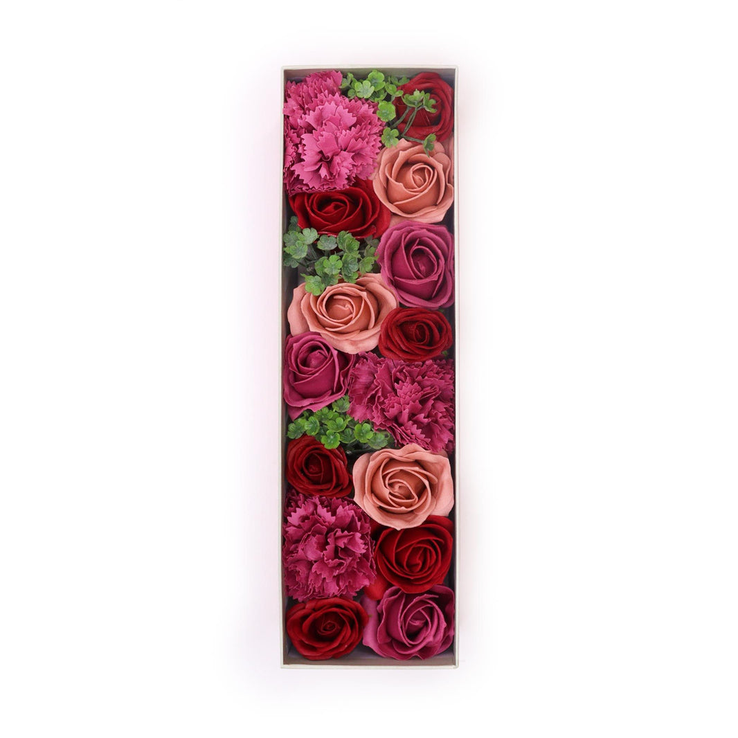 A luxury red long gift box filled with realistic antique-style pink and mauve soap roses arranged in a decorative display.