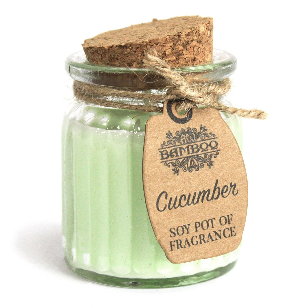 A small glass jar with light green scented soy wax and a simple rustic paper tag tied with string.
