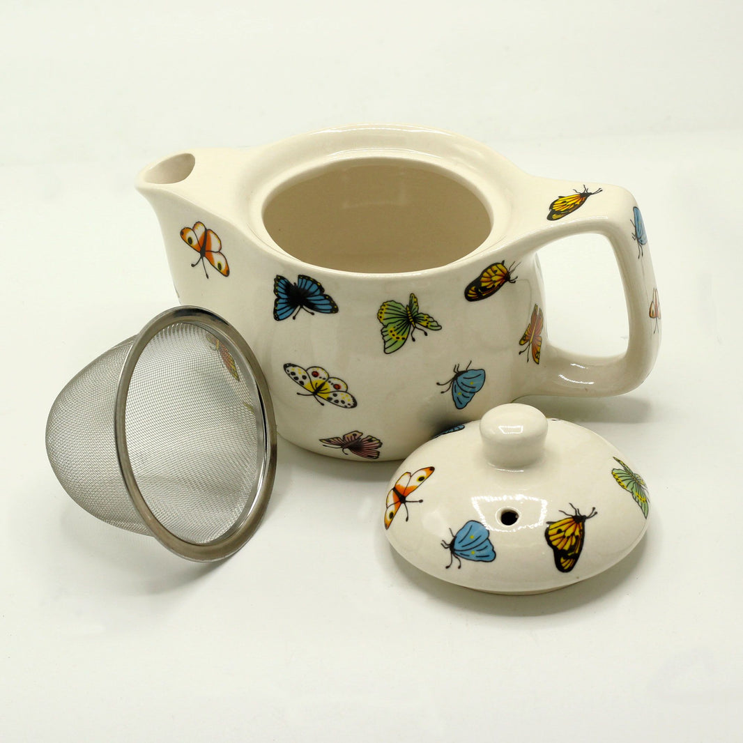 A small white ceramic teapot featuring colorful butterfly illustrations and floral accents for loose leaf tea.