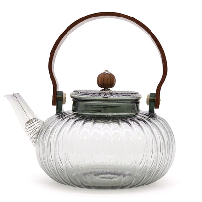 A large round glass teapot with charcoal-toned ribbed glass texture and a sturdy dark handle.