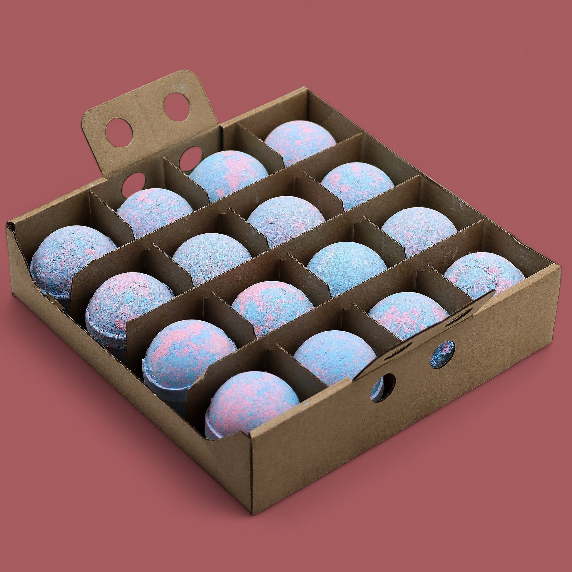 A wooden display crate holding sixteen large, marbled blue and white baby powder scented bath bombs.
