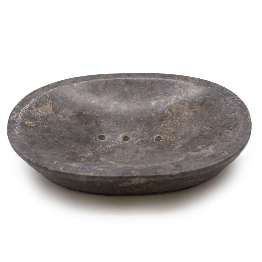 A polished oval soap dish carved from solid dark grey marble featuring natural white veining and carved drainage holes.