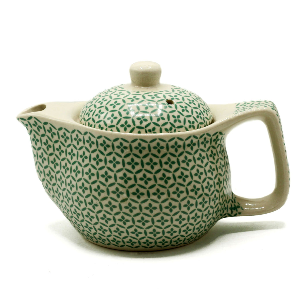 A small, rounded light green teapot decorated with a detailed geometric mosaic pattern and a matching lid.
