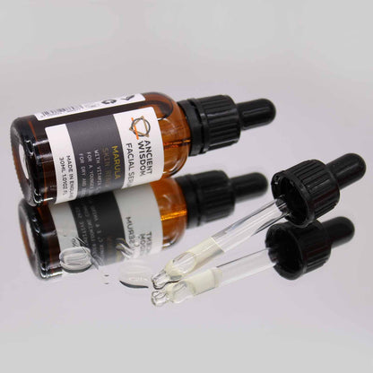 An amber glass dropper bottle of hyaluronic acid facial serum displayed with a modern, minimalist label.