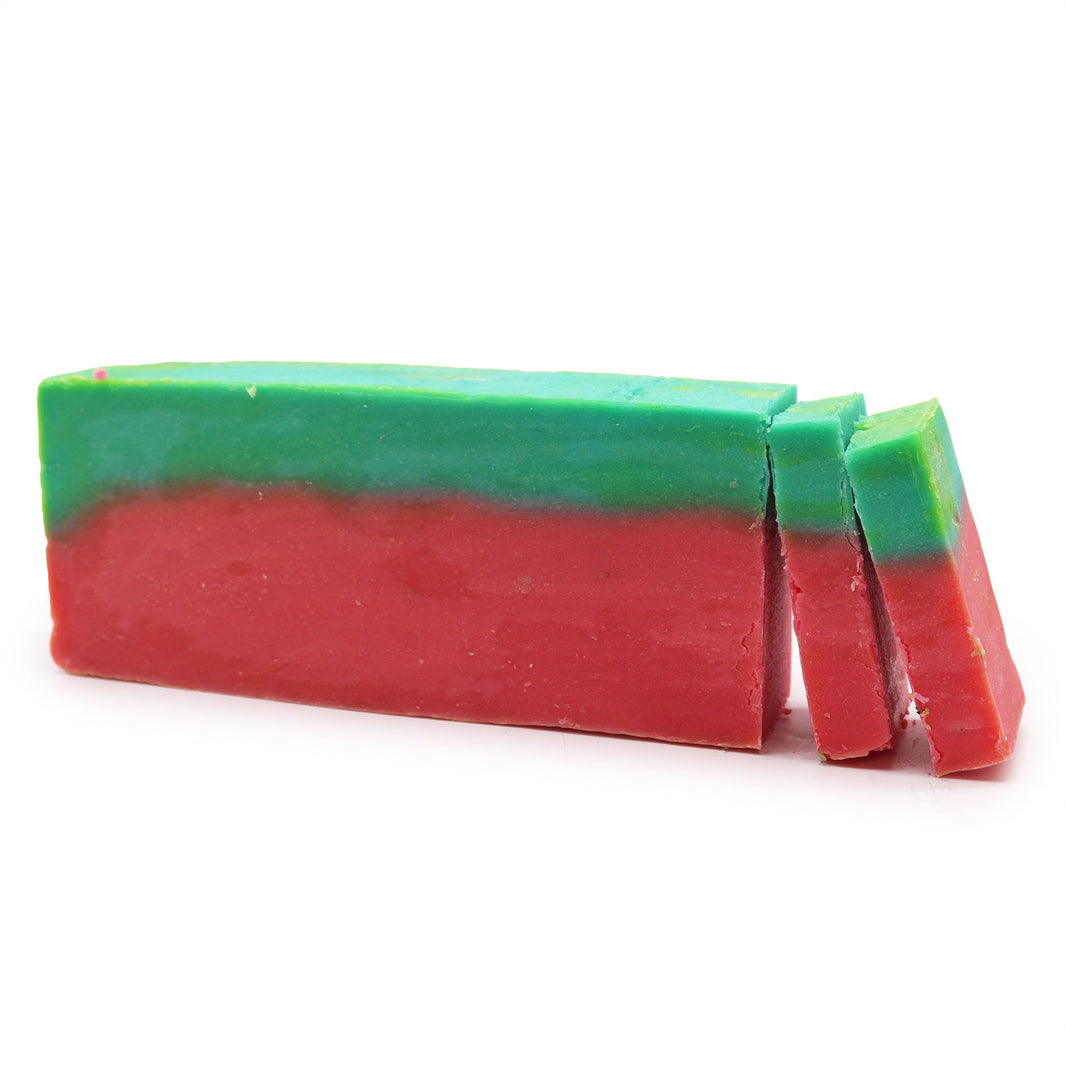 A 100g artisan soap slice designed to look like a watermelon slice with green, white, and red layers and poppy seed "seeds."
