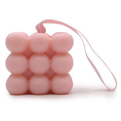 A pink massage soap bar featuring a bubbly texture designed for skin stimulation and aromatic muscle relief.