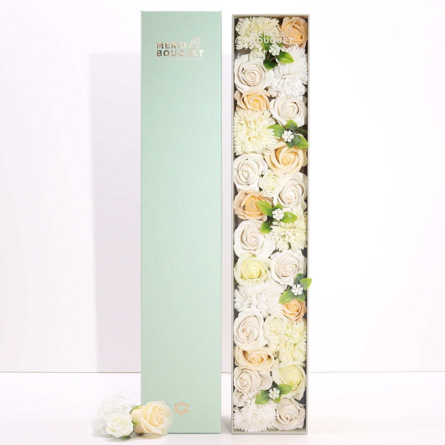 A tall, slender white gift box decorated with elegant gold and floral patterns, containing a selection of premium bath products.