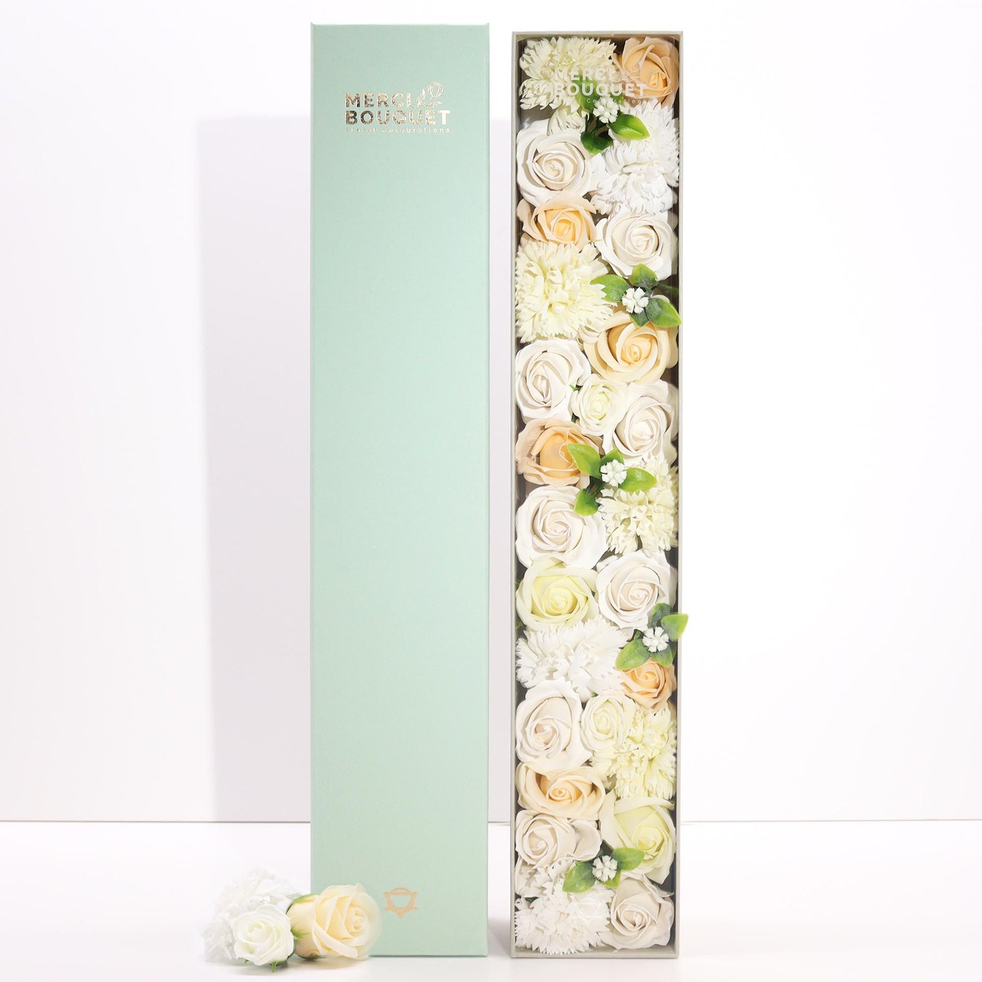 A tall, slender white gift box decorated with elegant gold and floral patterns, containing a selection of premium bath products.
