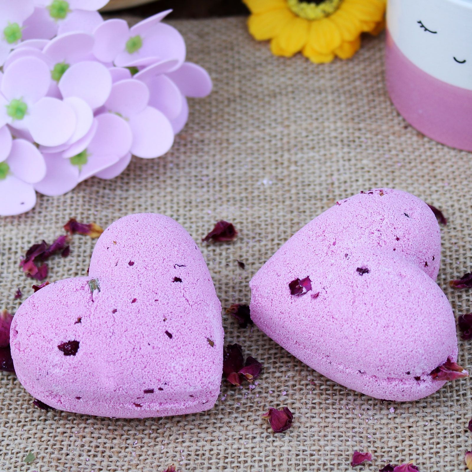 A purple heart-shaped 70g bath bomb featuring a romantic blend of ylang ylang and rose essential oils.