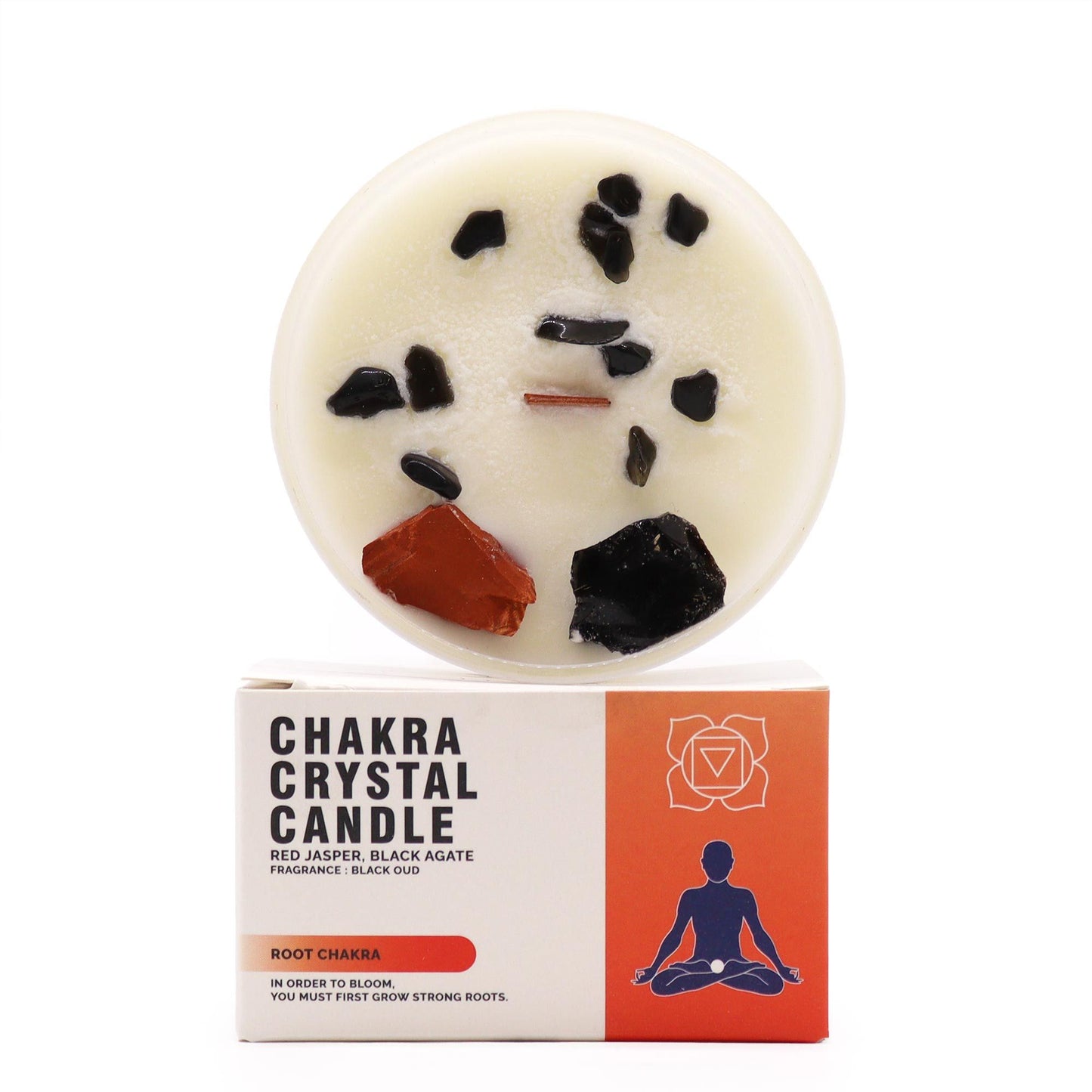 Root Chakra soy candle featuring raw red jasper crystals and earthy botanicals in a glass jar next to its box.