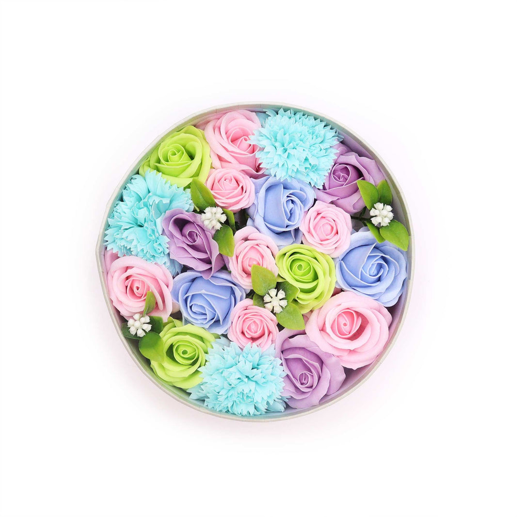 A round decorative gift box containing a soft arrangement of blue and white soap flowers for baby showers.