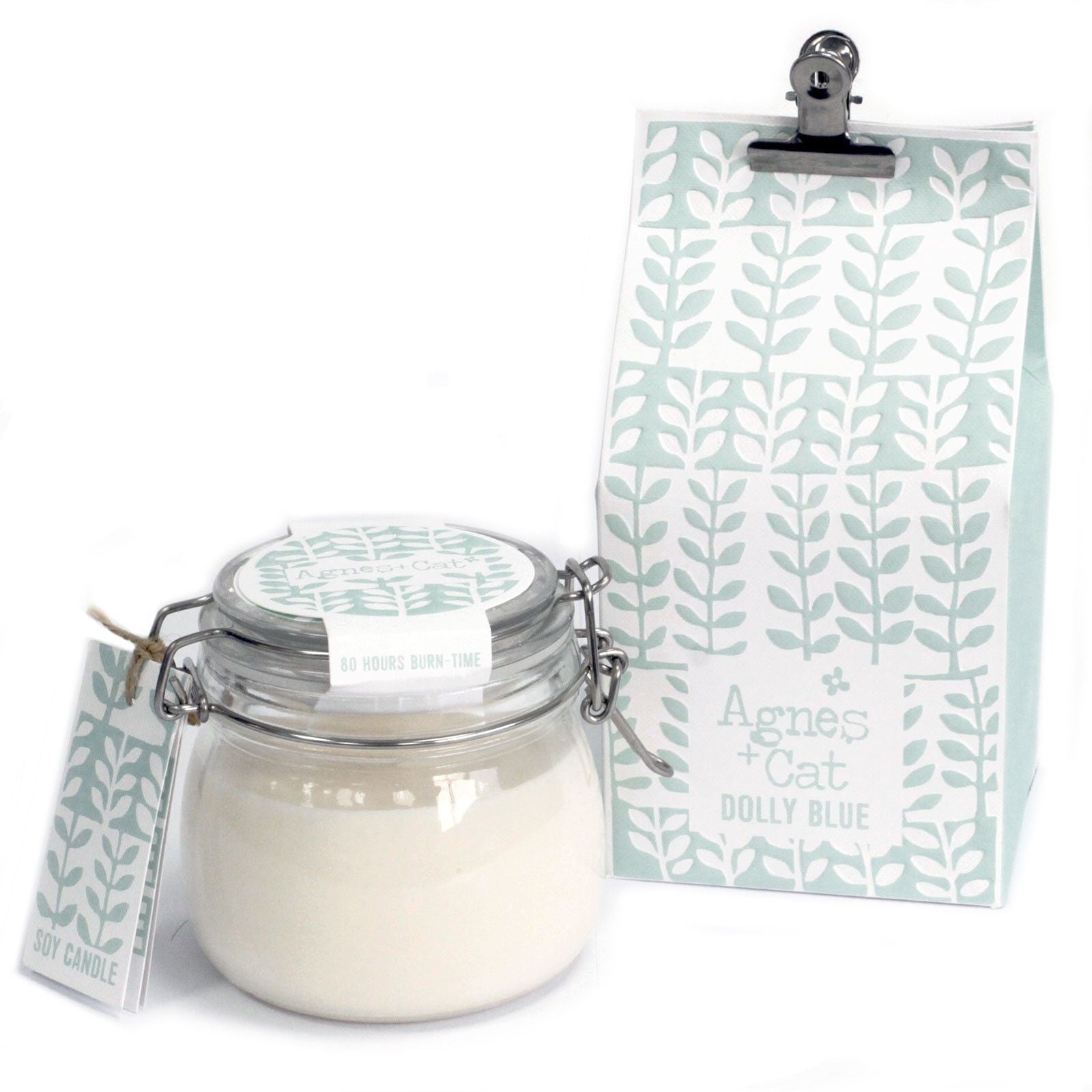 A small glass Kilner jar with a traditional metal wire closure containing a fresh-scented white soy candle and a blue patterned tag.