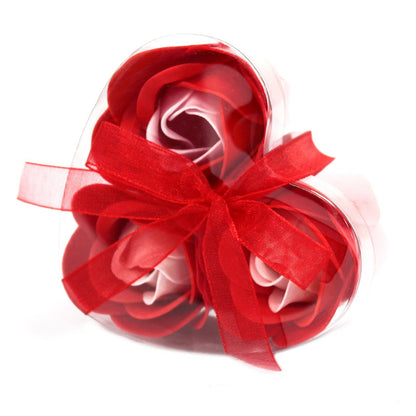 A small heart-shaped red gift box containing three realistic red soap rose flowers.