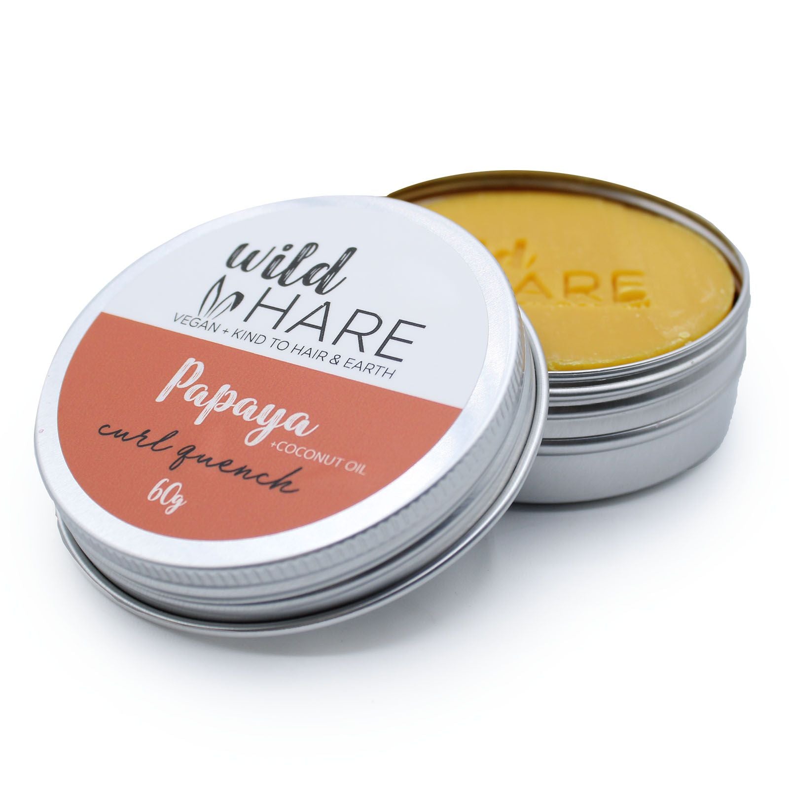 A 60g Wild Hare solid shampoo bar with an orange label, scented with tropical papaya and stored in a travel-ready tin.