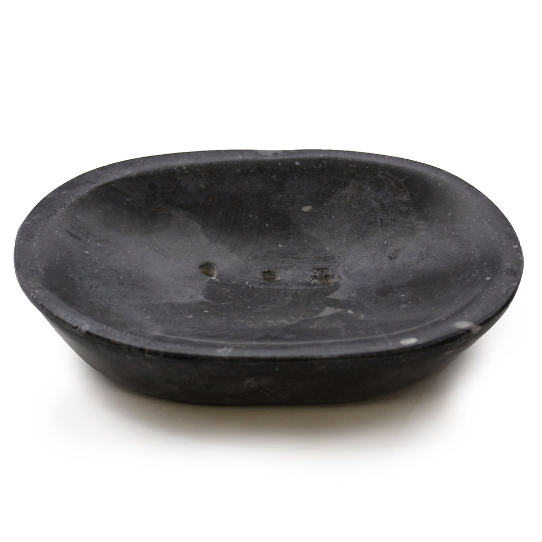 A smooth, polished oval soap dish carved from solid black marble with natural grey veining throughout.