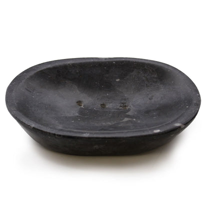 A smooth, polished oval soap dish carved from solid black marble with natural grey veining throughout.