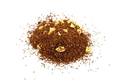 A high-volume display of a diverse herbal tea blend containing various dried fruits, flower petals, and assorted herbal leaves.