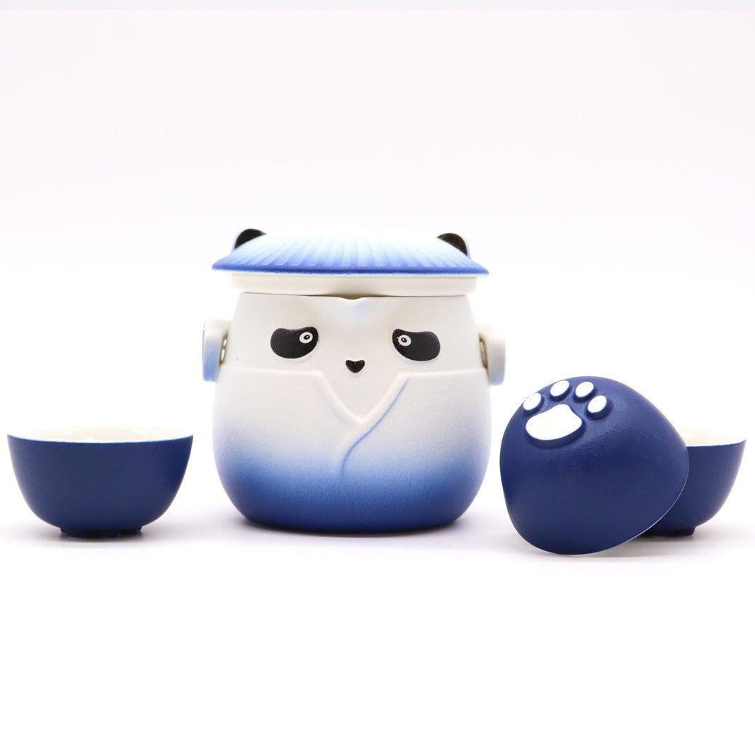 A light blue and white ceramic teapot featuring a cute panda design, accompanied by three matching handleless tea cups.