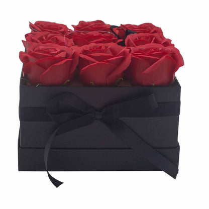 A black square gift box featuring 9 realistic red soap roses arranged in a classic floral display.