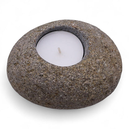 A smooth, naturally rounded grey riverstone with a single circular cutout for a tea light candle.
