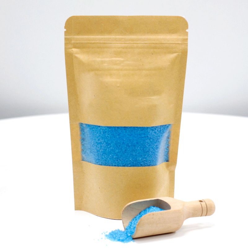 A kraft paper pouch featuring a blue label, filled with deep blue aromatherapy salts designed for intense stress relief.