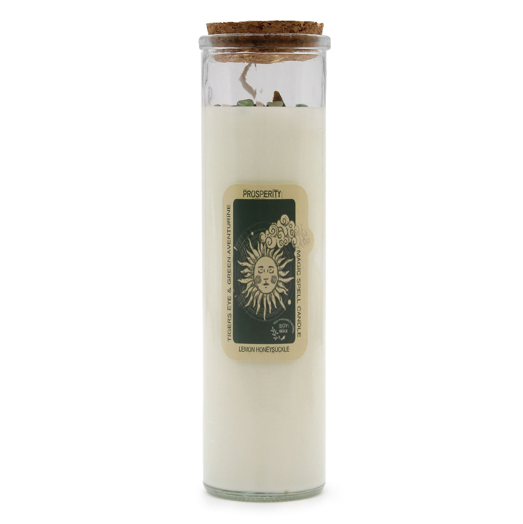 A tall white pillar ritual candle with a green-themed 'Prosperity' label featuring ancient symbols of wealth.