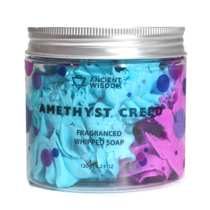 A clear jar containing light purple and blue swirled whipped cream soap with a thick, decadent, and pipeable texture.